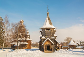 Fototapeta premium Suzdal in winter. Rural log churches - a sample of Russian wooden architecture.