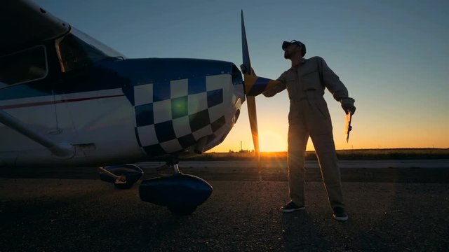 Sunset take-off runway with a male service engineer cleaning the airplane