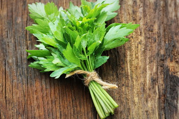 Bunch of lovage herb on wooden background