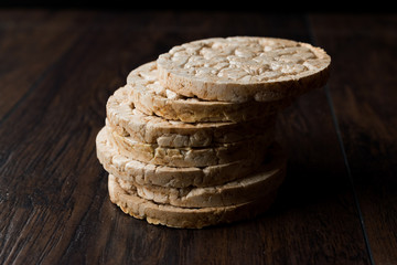 Bulgur Rice Cake Crackers Round Shaped on Dark Wooden Surface.