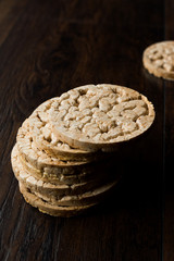 Bulgur Rice Cake Crackers Round Shaped on Dark Wooden Surface.