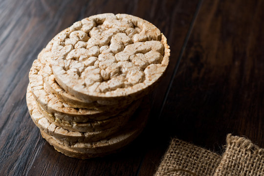 Bulgur Rice Cake Crackers Round Shaped on Dark Wooden Surface.