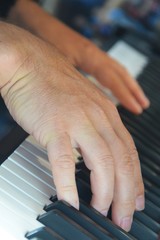 Spielende Hände eines Mannes am Klavier