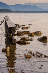 Steg und Steine vor Alpenkulisse am See