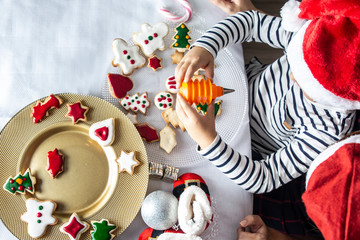 Mother and son decorating Christmas biscuits at home