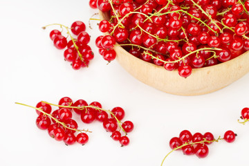 ripe juicy currant branches in a plate on white table