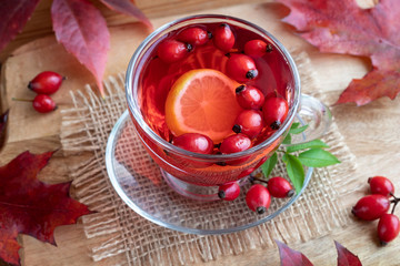 A cup of rosehip tea with fresh rosehips