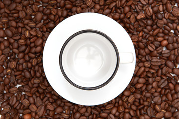 White Coffee Cup and saucer on coffee beans with copy space