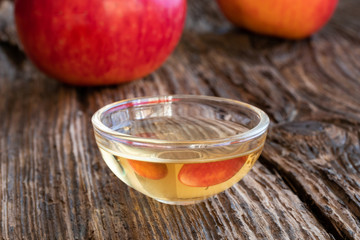 Apple cider vinegar with fresh apples in the background
