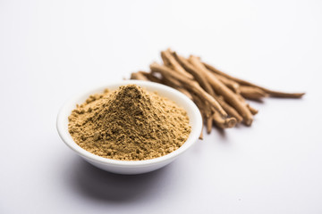 Ashwagandha / Aswaganda OR Indian Ginseng is an Ayurveda medicine in stem and powder form. Isolated on plain background. selective focus