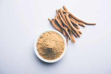 Ashwagandha / Aswaganda OR Indian Ginseng is an Ayurveda medicine in stem and powder form. Isolated on plain background. selective focus