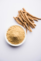 Ashwagandha / Aswaganda OR Indian Ginseng is an Ayurveda medicine in stem and powder form. Isolated on plain background. selective focus