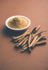 Ashwagandha / Aswaganda OR Indian Ginseng is an Ayurveda medicine in stem and powder form. Isolated on plain background. selective focus