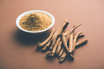 Ashwagandha / Aswaganda OR Indian Ginseng is an Ayurveda medicine in stem and powder form. Isolated on plain background. selective focus
