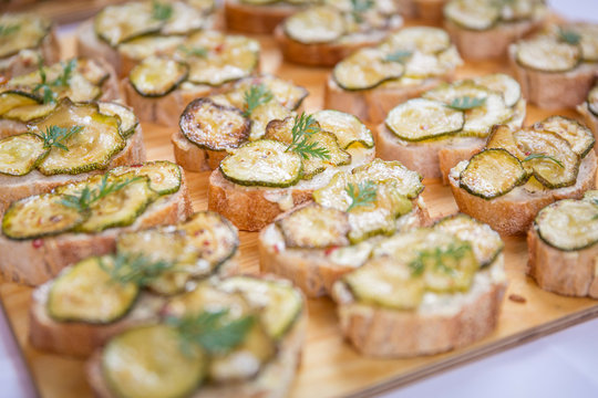 Catering / Belegte Brote mit Zucchini und Käse überbacken auf Holzbrett