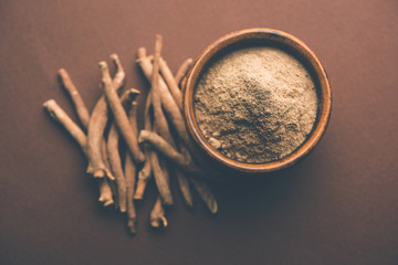 Ashwagandha / Aswaganda OR Indian Ginseng is an Ayurveda medicine in stem and powder form. Isolated on plain background. selective focus