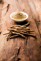 Ashwagandha / Aswaganda OR Indian Ginseng is an Ayurveda medicine in stem and powder form. Isolated on plain background. selective focus