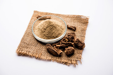 Fototapeta na wymiar Hemidesmus indicus also known as Ananthamoola or Naruneendi or Nannari in dried steam and powder form. It's a useful Ayurvedic medicine from India