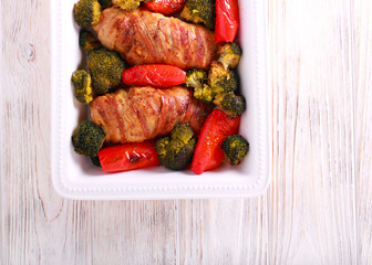 Stuffed chicken fillet  wrapped in bacon and broccoli, pepper