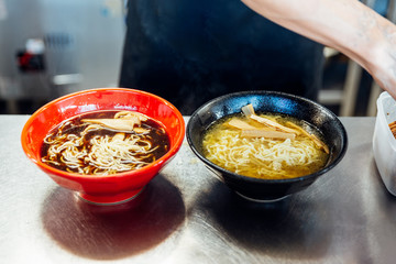 Chef adding ingredients in ramen noodle for making miso and shoyu ramen.