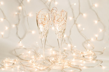 Two wine glasses with holiday lights inside