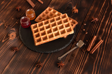 Tasty fresh Vienna wafers, jam and cup of coffee on a dark wooden background