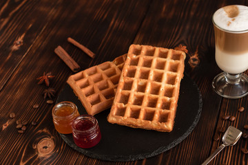 Fototapeta na wymiar Tasty fresh Vienna wafers, jam and cup of coffee on a dark wooden background