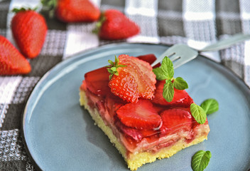 Classic traditional German Strawberry Cake on blue dish with mint leaf and fresh strawberry.