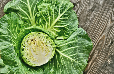 Obraz premium Colorful of cabbage cut half with water drop on wooden background.
