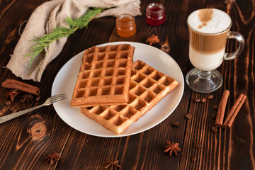 Tasty fresh Vienna wafers, jam and cup of coffee on a dark wooden background
