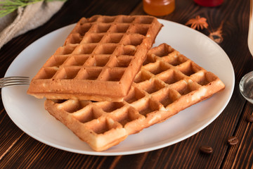 Tasty fresh Vienna wafers, jam and cup of coffee on a dark wooden background