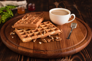 Tasty fresh Vienna wafers, jam and cup of coffee on a dark wooden background