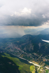 Luftaufnahme aus einem Segelflugzeug mit Blick über eine Berglandschaft im Regen