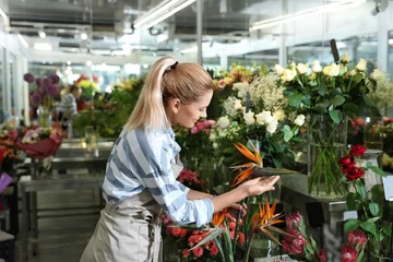 Fototapete Blumenladen Schöne weibliche Floristin, die im Blumenladen arbeitet