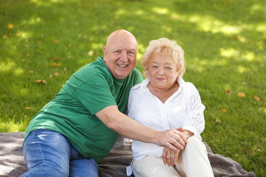 Happy elderly couple in park on sunny day