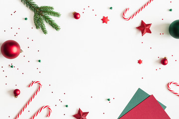 Christmas composition. Envelope, fir tree branches, red and green decorations on white background. Christmas, winter, new year concept. Flat lay, top view, copy space