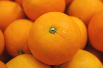 Closed up vibrant color fresh ripe mandarin orange on top of the pile 