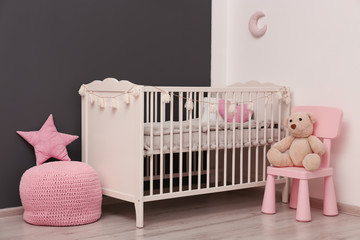 Stylish baby room interior with comfortable crib