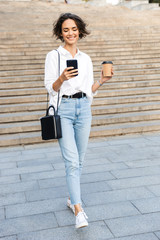 Beautiful young woman walking downstairs at the street