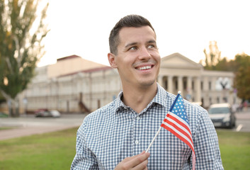 Man with American flag on city street