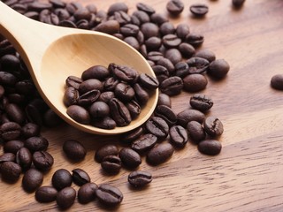 Top view Coffee beans in wooden spoon on wooden table background.
