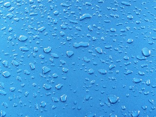 Blue water drops, detail of blue surface water-repellent on glass for background.