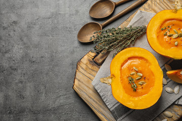 Flat lay composition with cream soup served in pumpkin and space for text on table