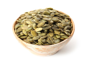 Shelled raw pumpkin seeds in bowl on white background