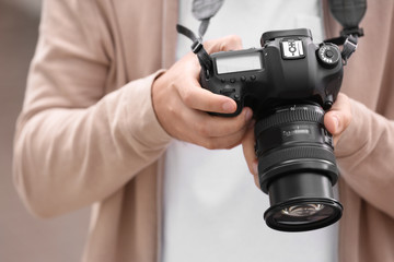 Male photographer with professional camera, closeup view
