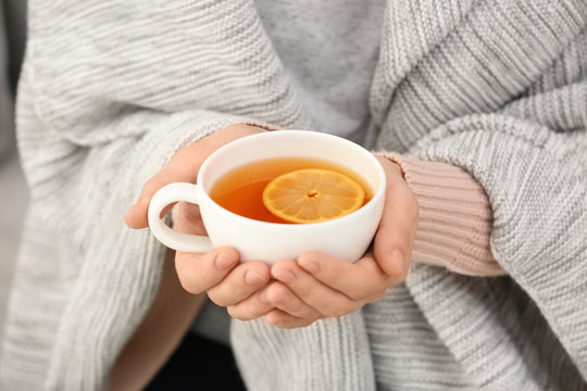 Woman with cup of hot tea for cough, closeup