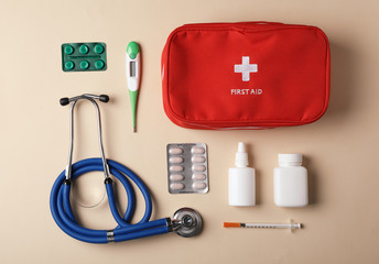 Flat lay composition with first aid kit on color background