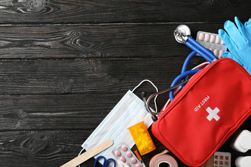 Flat lay composition with first aid kit and space for text on dark background