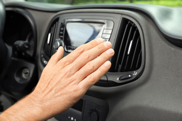 Man checking work of air conditioner in car, closeup