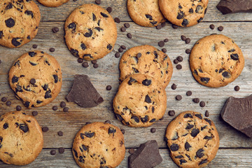 Delicious chocolate chip cookies on wooden table, flat lay